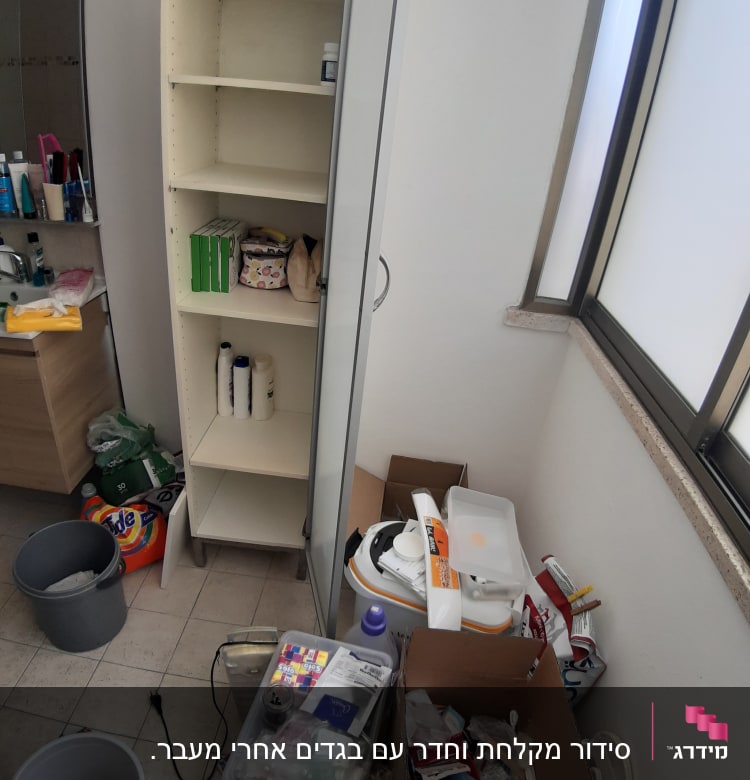 ארון פתוח עם מדפים, קופסאות ופריטים לארגון